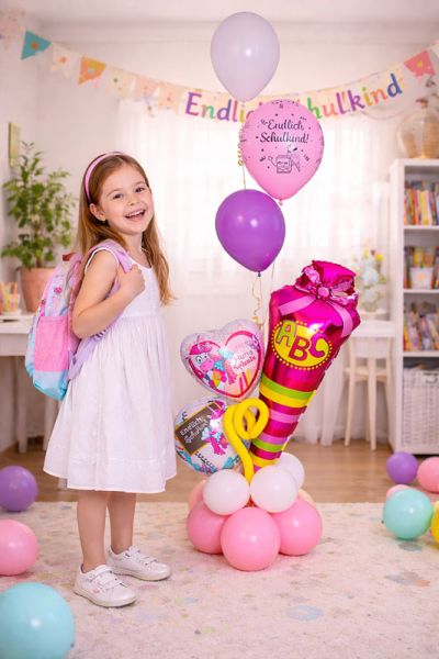 Schulkind neben Ballonbouquet